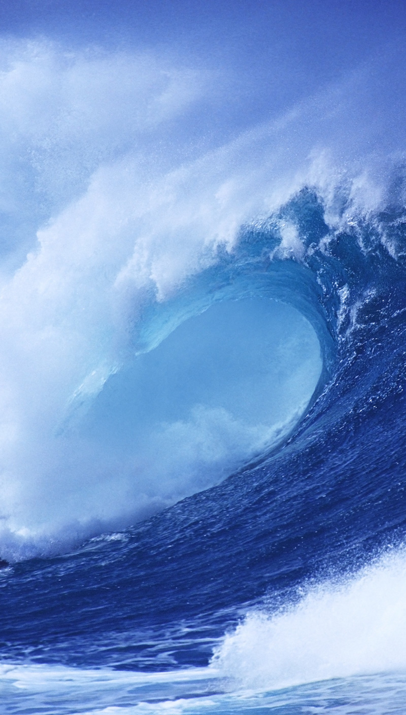 Un surfeur chevauchant une grande vague dans l'océan par une journée ensoleillée (pomme, plage, bleu, hd, ios)