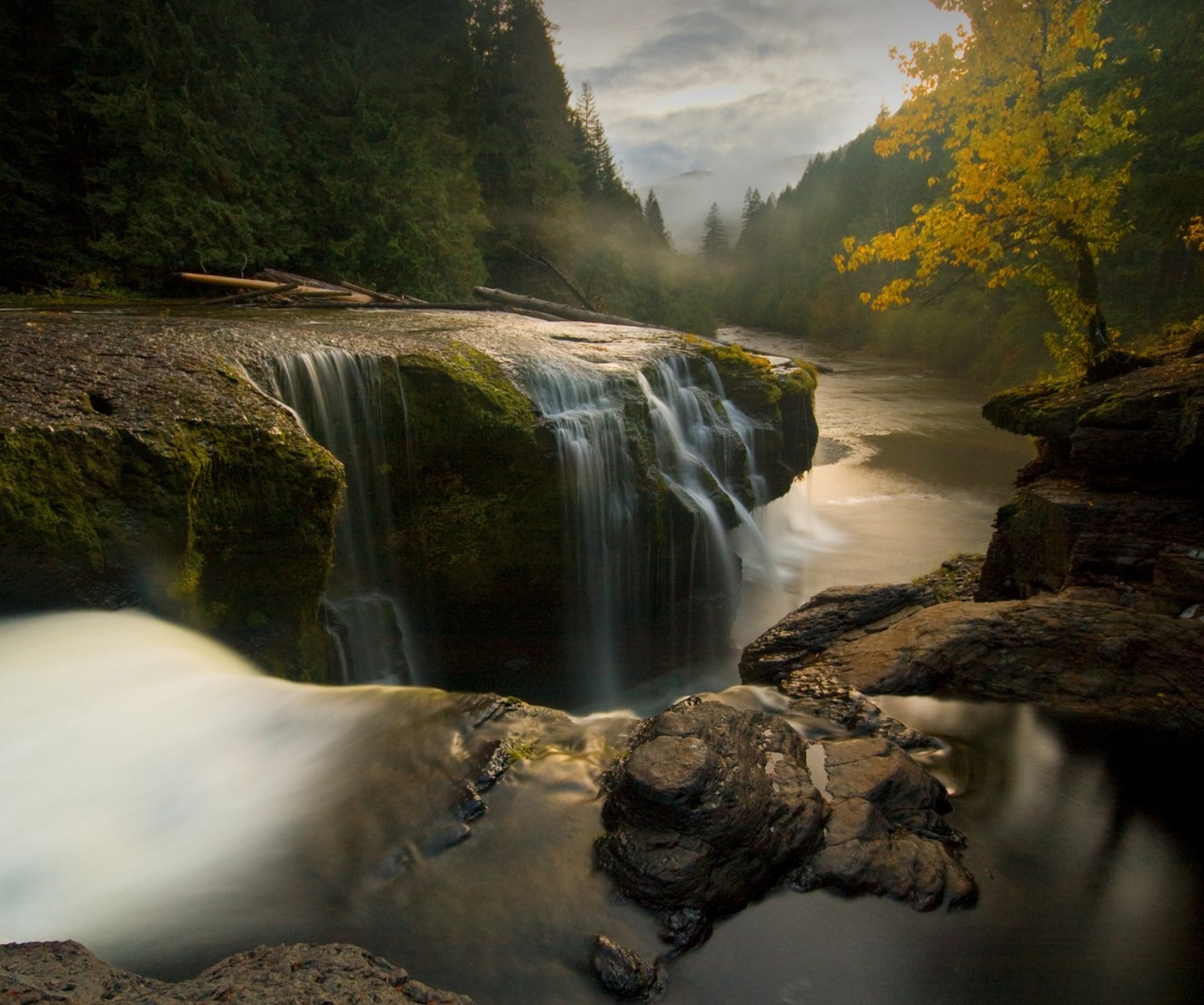 Una cascada que fluye sobre las rocas en el bosque (hermoso, paisaje, montaña, naturaleza, rio)