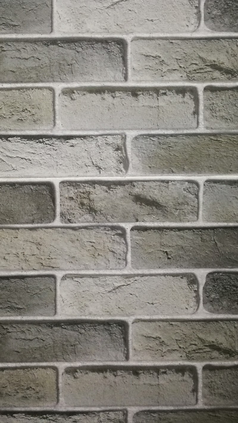 A close up of a brick wall with a black and white picture (huawei, samsung)