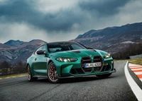 2024 BMW M4 CS in a striking green finish, showcased on a racetrack with a dramatic mountainous backdrop.