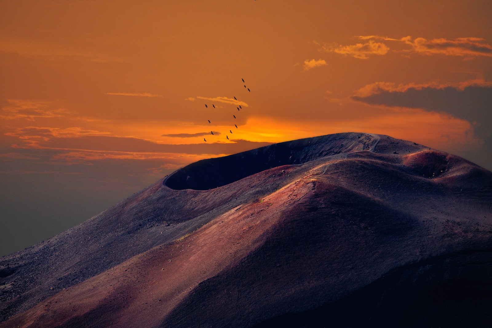 Des oiseaux volent au-dessus d'une montagne au coucher du soleil (volcan, nature, nuage, horizon, coucher de soleil)