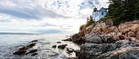 Lighthouse Overlooking Azure Waters and Rocky Shoreline