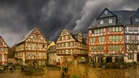 Bâtiments historiques dans un charmant quartier résidentiel sous un ciel dramatique.