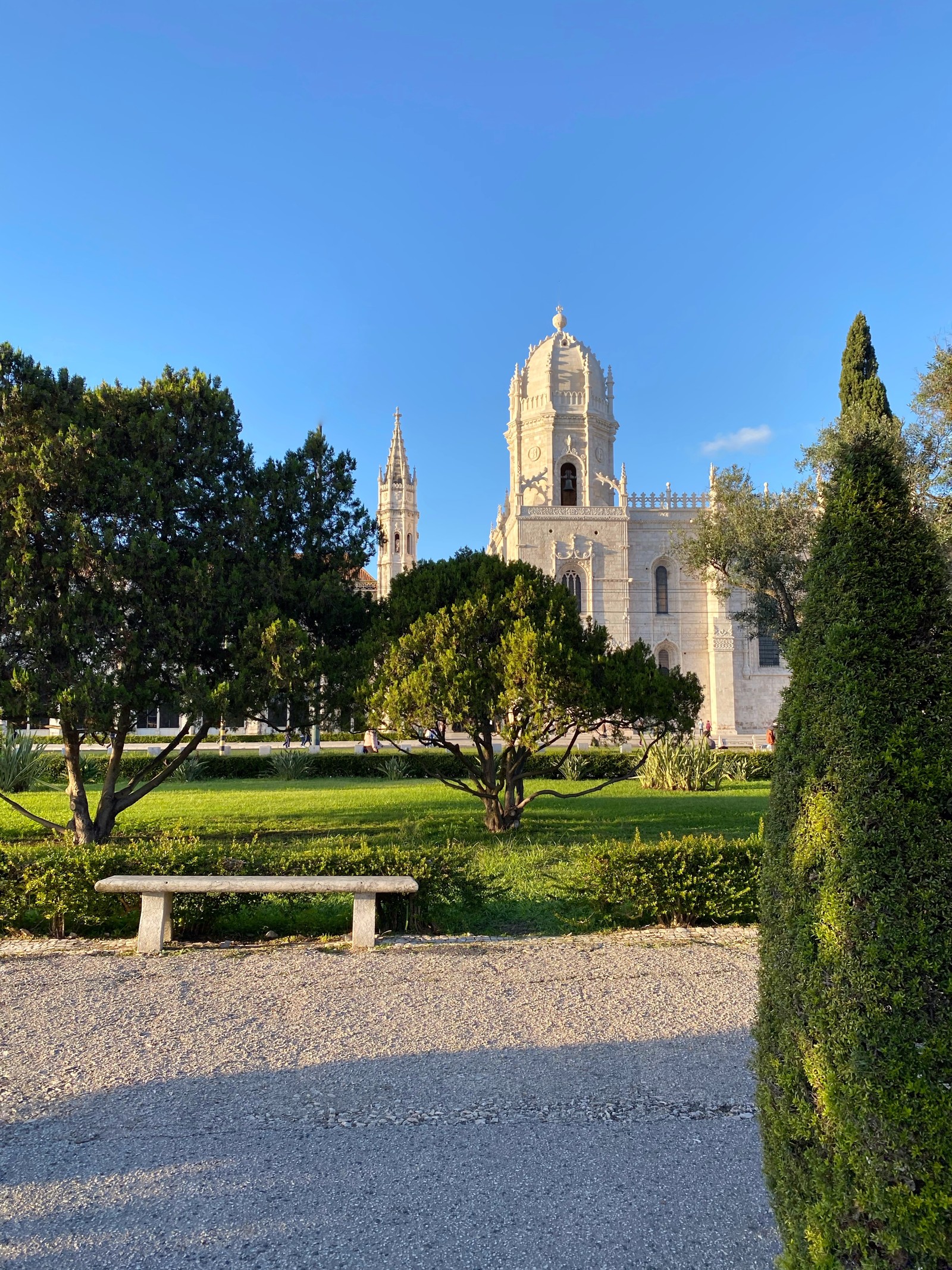 Vista aérea de um grande edifício branco com uma torre do relógio (árvore, arbusto, jardim, sempre verde, parque)