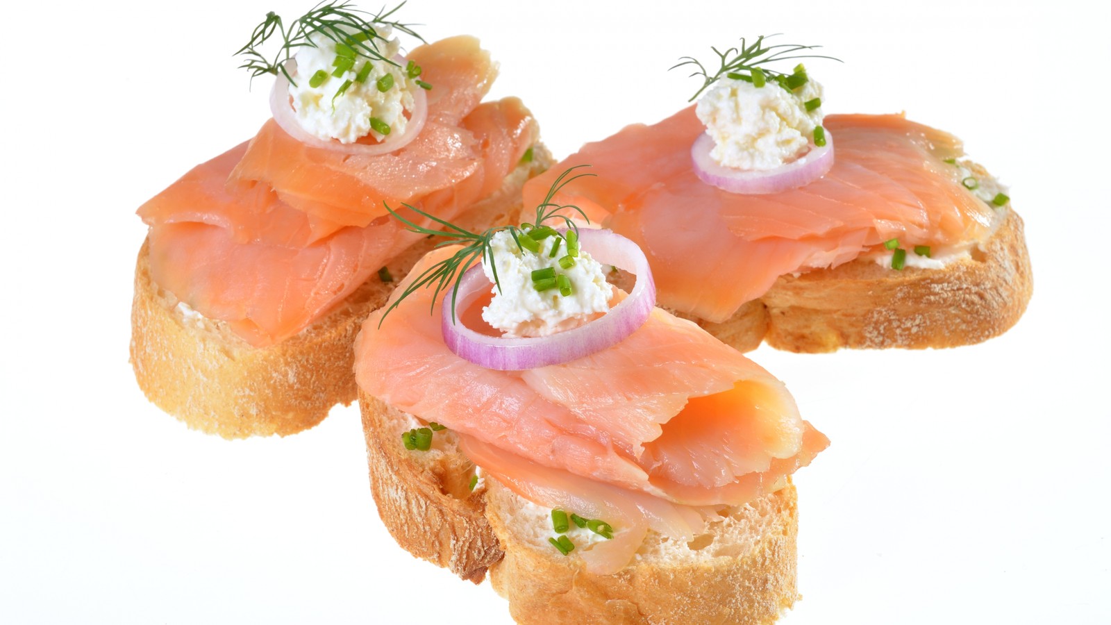 Drei stücke brot mit lachs und zwiebeln oben. (butterbrot, geräucherter lachs, fischsteak, meeresfrüchte, lachs)