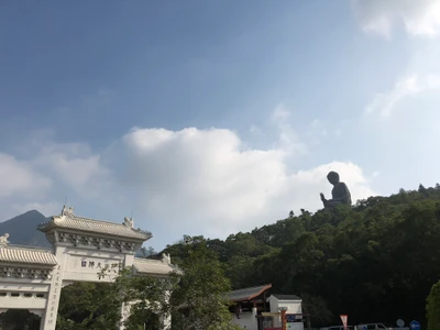 Tian Tan Buddha, der traditionelle Architektur unter Kumuluswolken überblickt