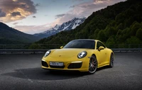 Porsche 911 amarelo estacionado contra um majestoso cenário montanhoso ao crepúsculo.