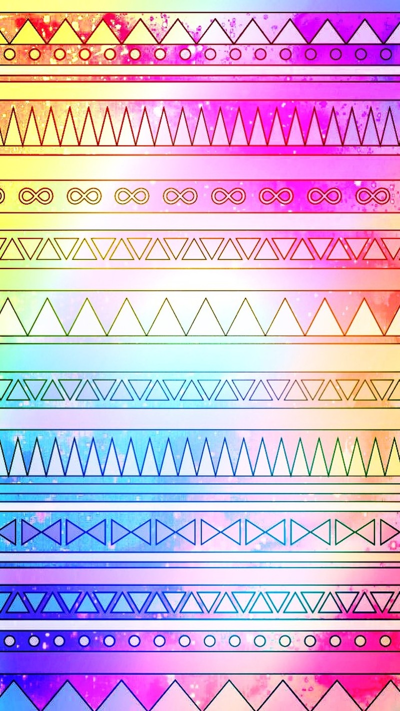 A close up of a colorful pattern with a rainbow background (aztec, faded)