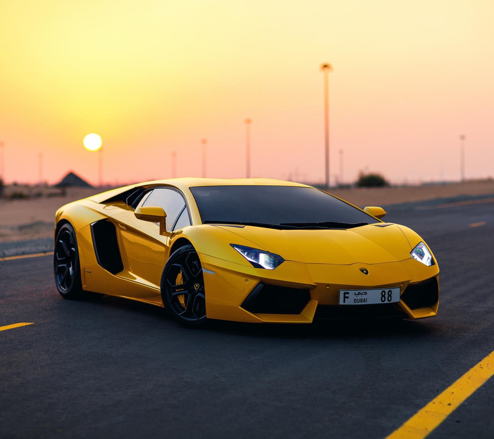 Un primer plano de un coche deportivo amarillo conduciendo por una carretera (lamborghini, supercoche, amarillo)