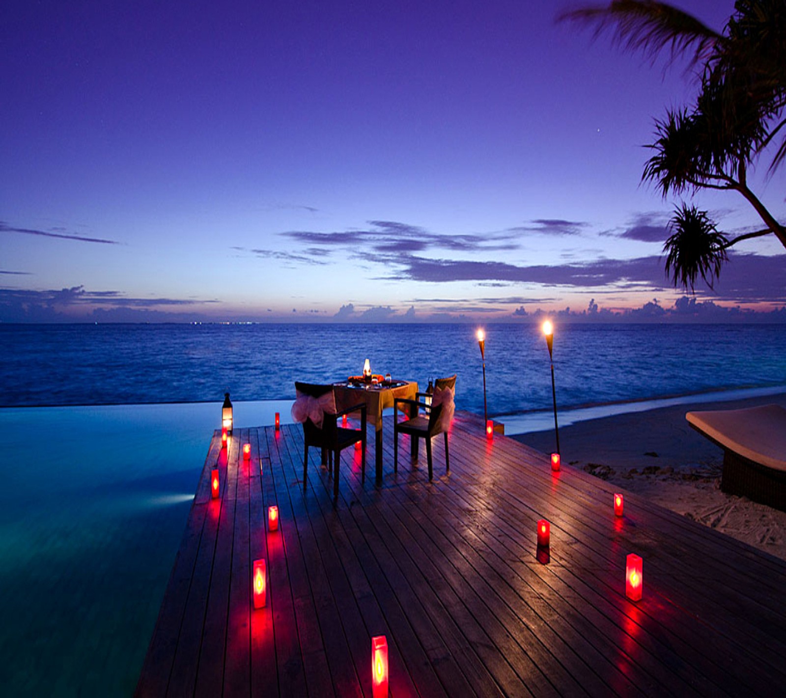 As velas estão acesas em um deck de madeira com vista para o oceano (lugar, romântico)