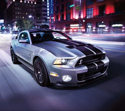 Sleek Shelby Cobra en movimiento entre luces nocturnas urbanas