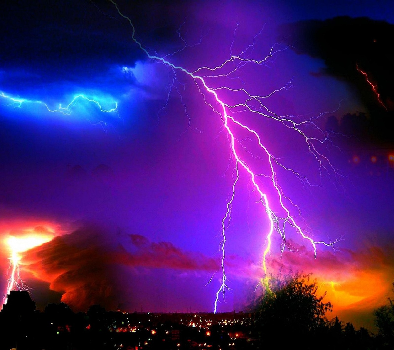 Lightning strikes through the sky over a city at night (storm)