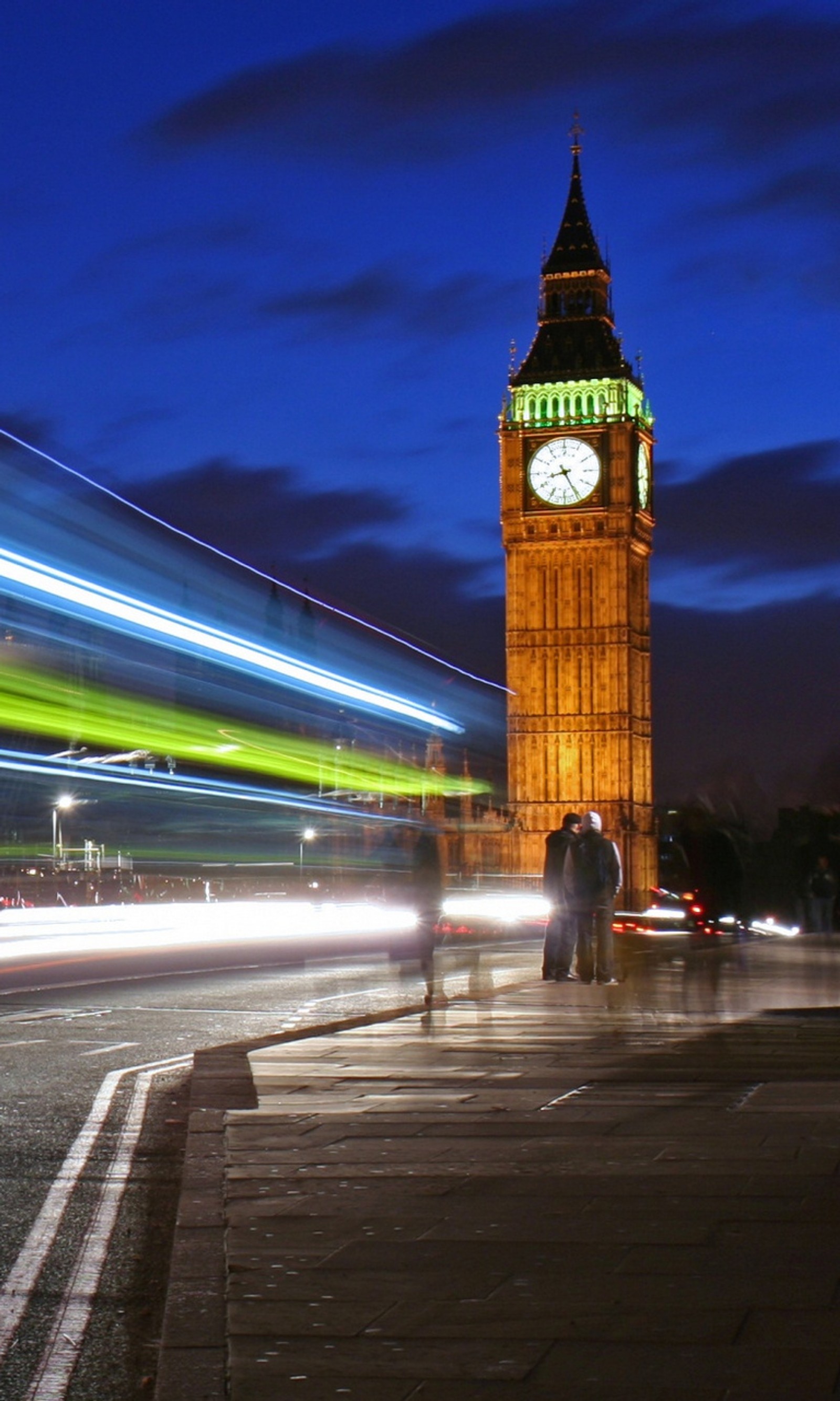 Araffes of a clock tower with a blurry image of a bus (ben, big, england, lights, night)