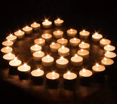 Espiral de velas de cera iluminadas em um ambiente escuro