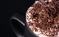 Decadent cappuccino topped with whipped cream and rich chocolate shavings.