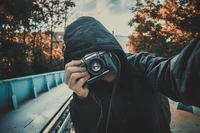 Genial selfie con una cámara réflex entre árboles de otoño