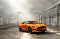 Ford Mustang laranja vibrante em um ambiente industrial