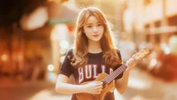 Chica tocando el ukelele en una calle iluminada por el sol