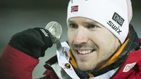 Norwegischer Athlet, der stolz eine Silbermedaille bei den Olympischen Winterspielen 2014 präsentiert und den Wettkampfgeist im Wintersport zeigt.