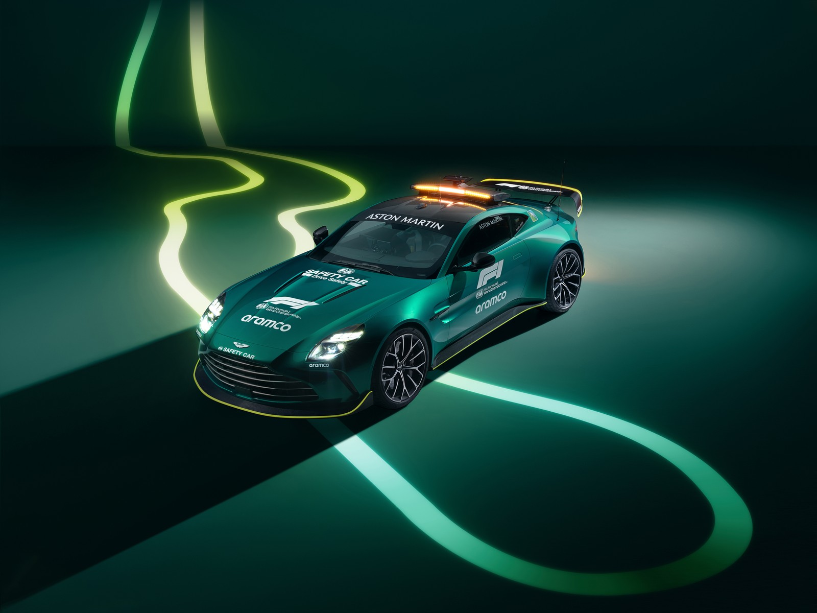 Une voiture verte avec une lumière sur le toit roulant sur la route (aston martin vantage, f1 safety car, 2024, 5k, voitures)