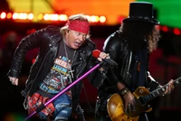 Guns N' Roses actuando en vivo durante la gira "Not in This Lifetime", con Axl Rose y Slash en un dinámico concierto de hard rock.