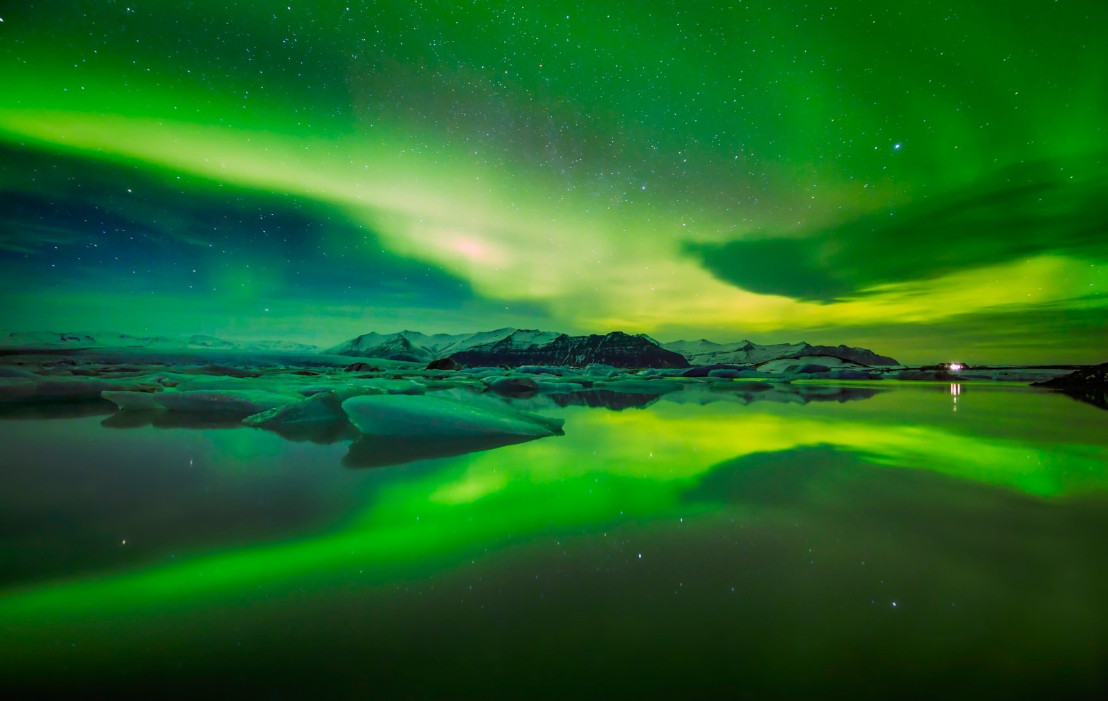 A aurora boreal é refletida na água de um lago glacial. (natureza, aurora, verde, atmosfera, água)