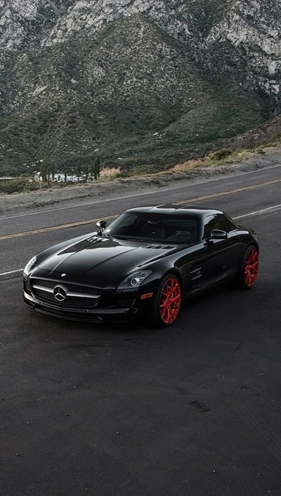 Schwarzer Mercedes SLS mit auffälligen roten Rädern auf einer Bergstraße.