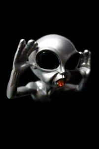 A metallic alien figure with large black eyes, cupping its hands around its mouth, and a red object in its mouth against a black background.