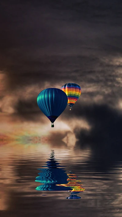 Des montgolfières colorées se reflètent sur une eau sereine sous un ciel dramatique.