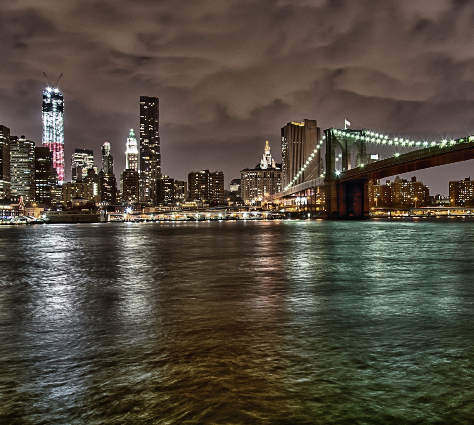 Vista desfocada do horizonte de uma cidade à noite com uma ponte (ponte, brooklyn, manhattan, noite, nyc)