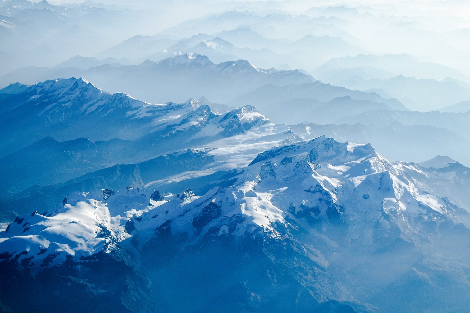 Berge, die mit schnee und wolken bedeckt sind, aus einem flugzeug gesehen (schweizer alpen, schneebedeckt, berge, gletscher, schweiz)