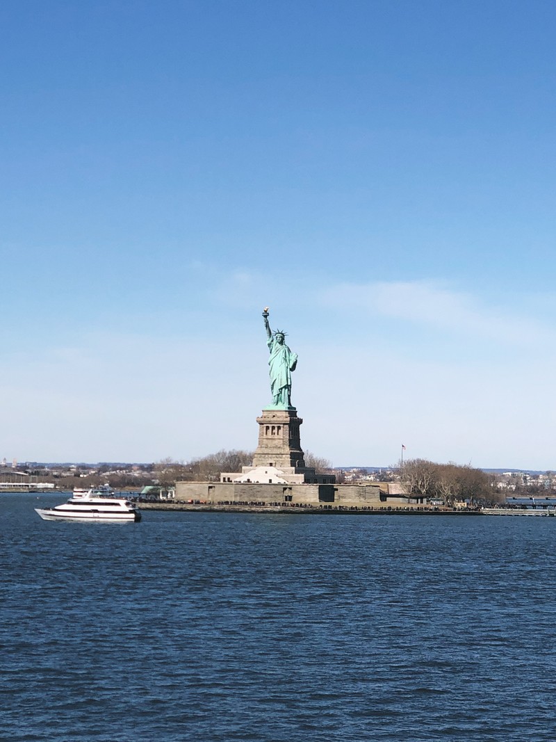 Статуя свободы на солнечном дне с лодкой на воде (нью йорк, new york city, статуя свободы, национальный памятник статуи свободы, корабль)