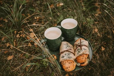 Kaffee und in Kräuter gewickelte Sandwiches auf einem rustikalen Picknicktablett