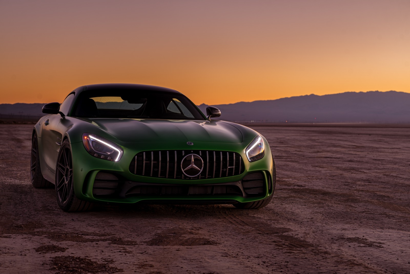 A green mercedes sports car parked in a desert area at sunset (car, sports car, supercar, performance car, mercedes amg)