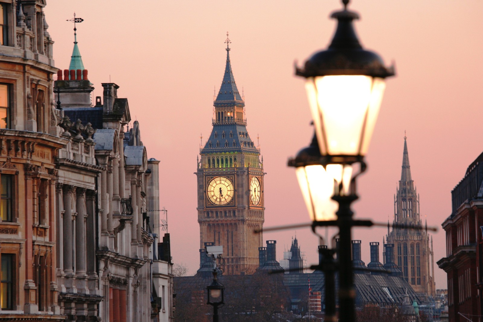 Vista panorámica de una torre del reloj a lo lejos con una farola delante (big ben, hito, aguja, pueblo, lámpara)