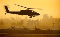 Hélicoptère AgustaWestland Apache en silhouette au coucher du soleil