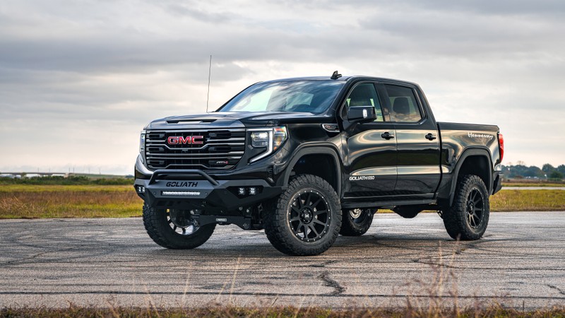 Черный грузовик gmc sierra припаркован на взлетной полосе под облачным небом (gmc sierra, хеннесси, hennessey, внедорожные грузовики, пикап)