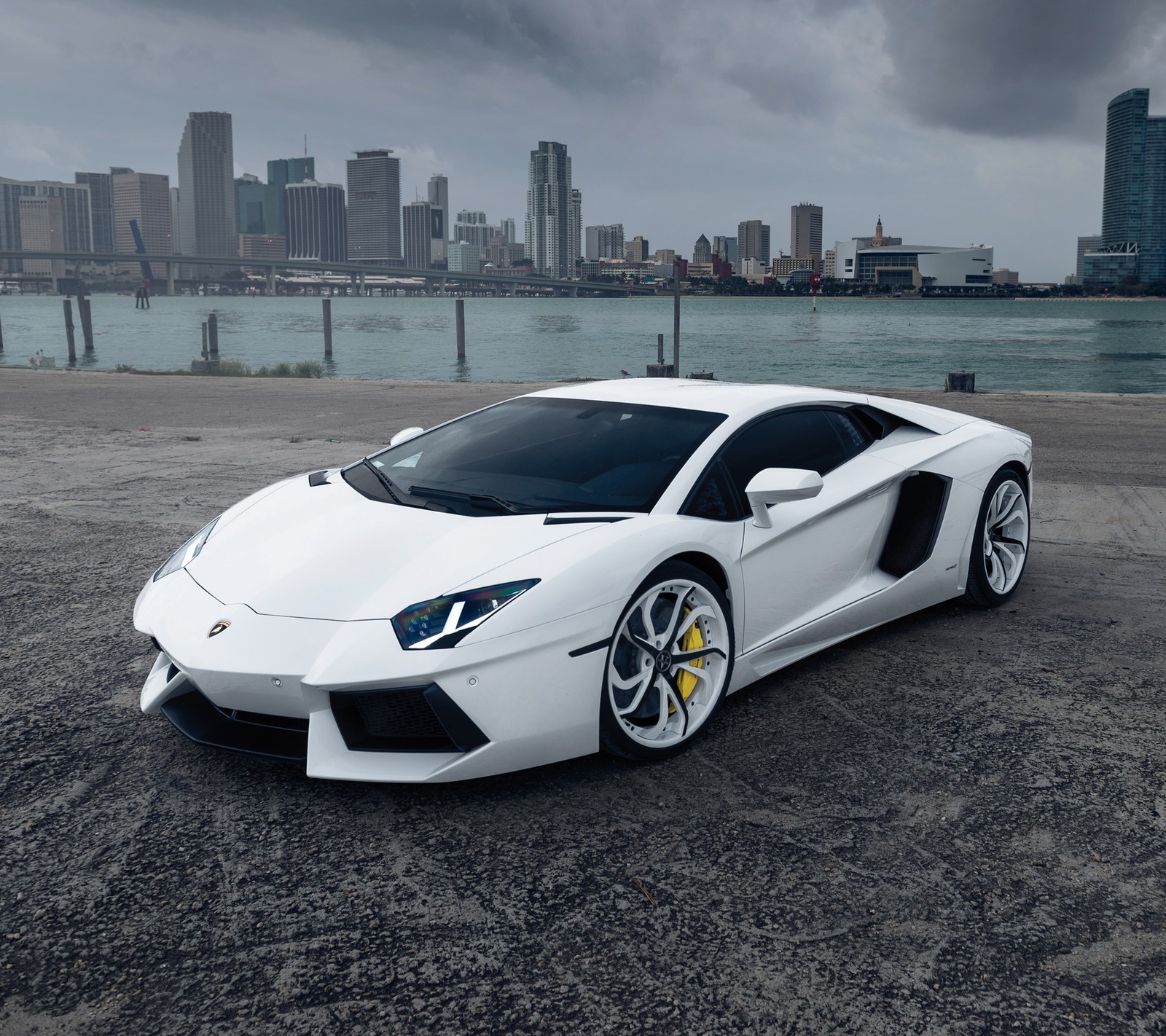 Gros plan d'une voiture de sport blanche garée dans un parking (lamborghini, supersportive, blanc)