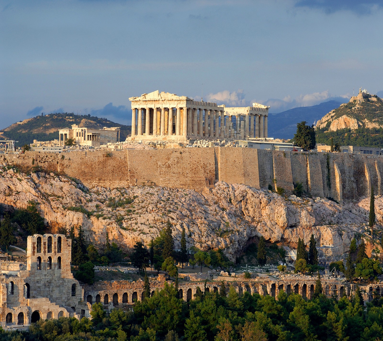 Vista aérea de uma grande estrutura de pedra em uma colina com algumas árvores (antigo, atenas, grécia, grego, templo)