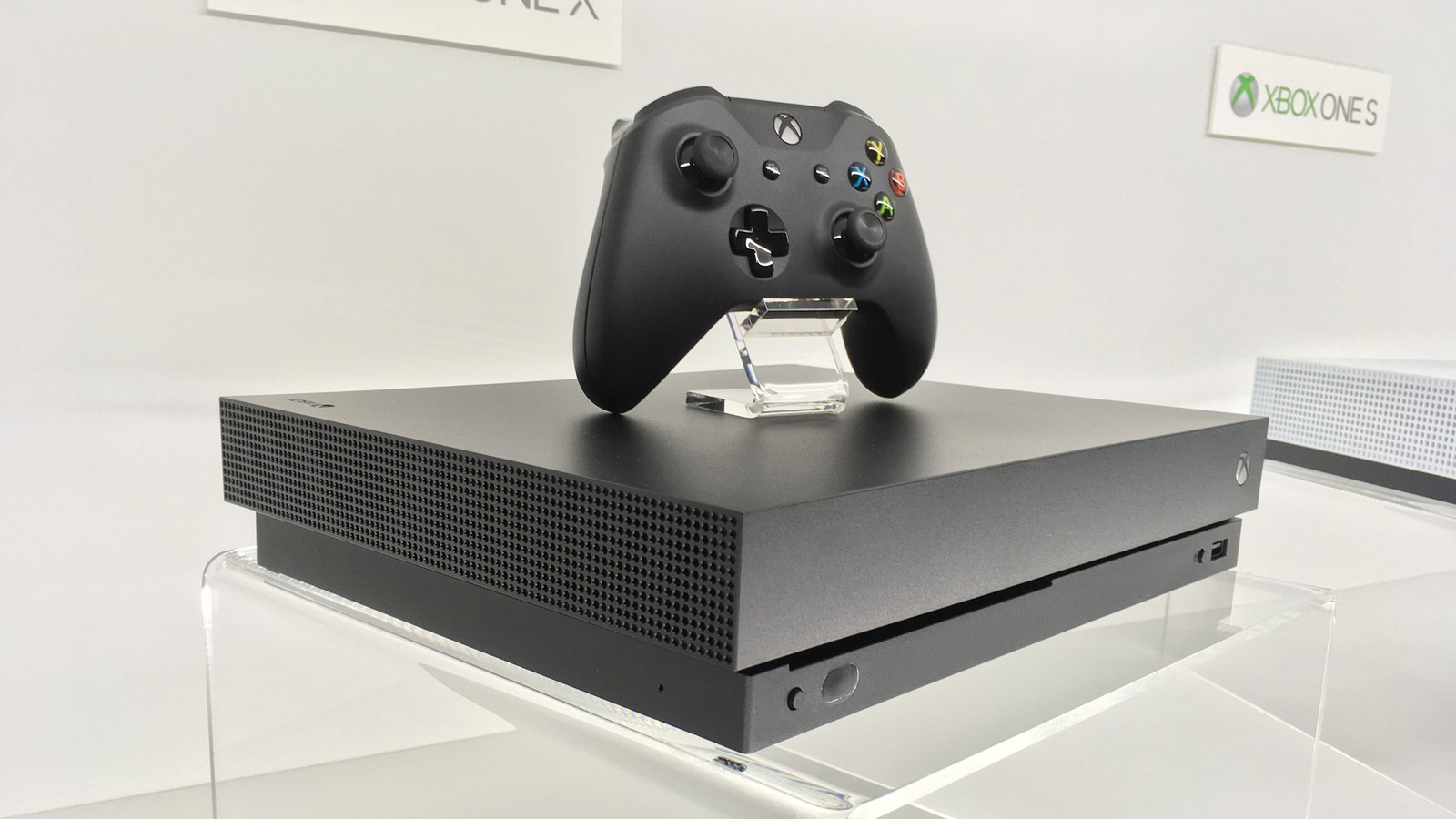 Xbox one mit einem controller oben drauf in einer auslage (spielsteuerung, joystick, xbox, xbox 360, gadget)