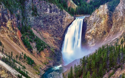 Lower Falls des Yellowstone River bei Sonnenaufgang – Ein majestätischer Wasserfall, umgeben von Klippen und üppigen Wäldern im Yellowstone-Nationalpark, Wyoming.