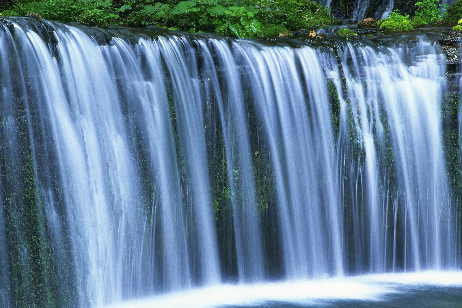 Waterfall with water flowing over rocks and green vegetation (waterfall, water resources, body of water, nature, water)