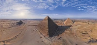 Panoramablick auf die Große Sphinx und die Pyramiden von Gizeh vor einem Wüstenhimmel