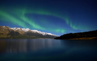 Aurora Boreal sobre el Lago Wakatipu con montañas glaciares cubiertas de nieve al amanecer