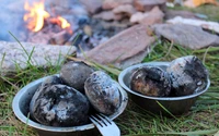 Batatas carbonizadas preparadas sobre uma fogueira