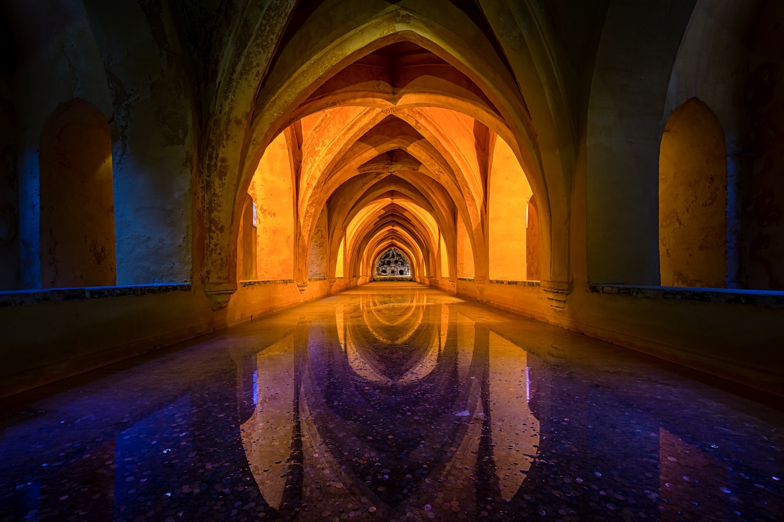 Une vue d'un long couloir avec le reflet de la lumière (arc, architecture, symétrie, bâtiment, lieu de culte)