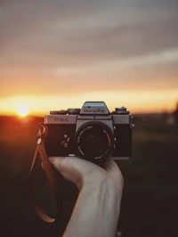 Câmera vintage Minolta contra um céu ao pôr do sol