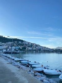 Vista serena do lago com barcos e casas na encosta