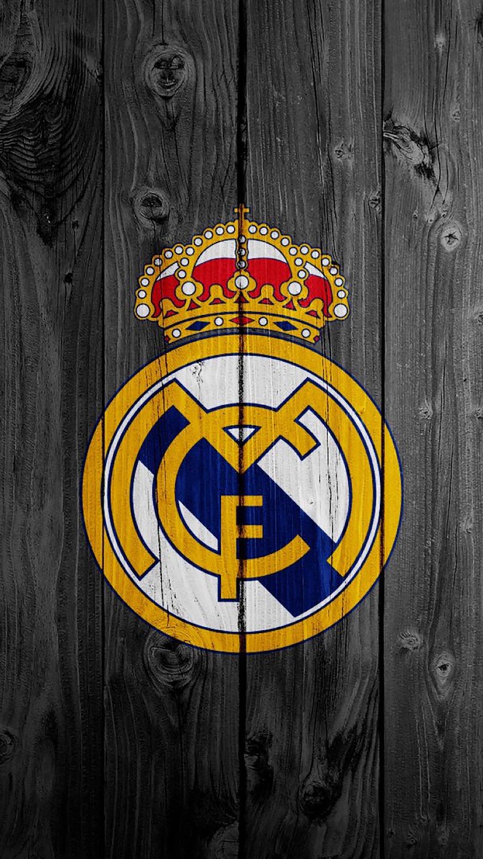 Un primer plano de una cerca de madera con el logo del real madrid (calcio, soceta)