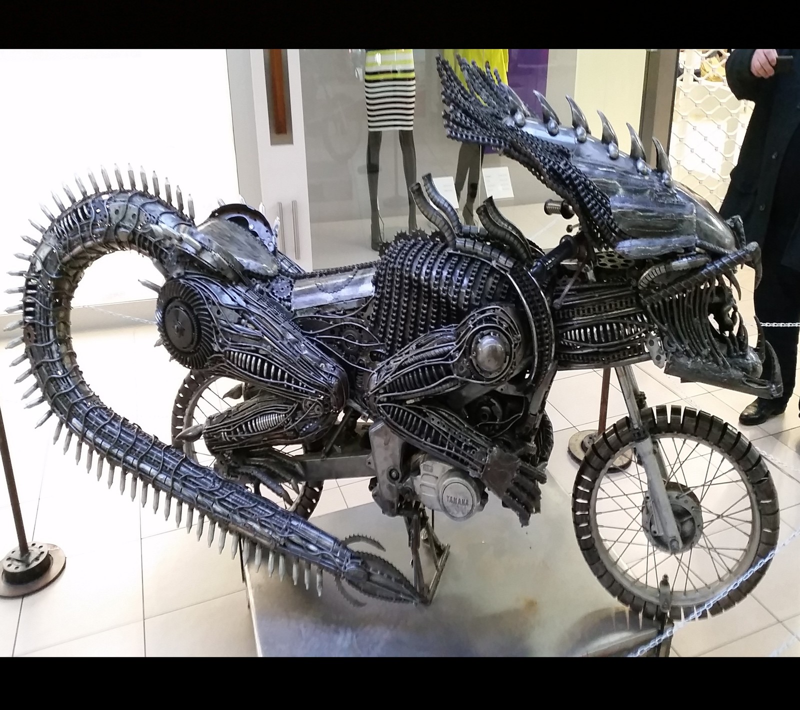 Há uma escultura em metal de um dragão em exibição em um museu (05, 011)